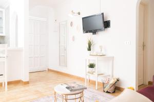 a white living room with a tv on a wall at Adults Only Sunny Quiet Apartment in Center of Las Americas in Arona