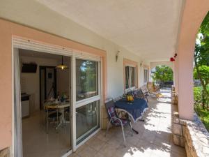 a house with a patio with a table and chairs at Apartments Vanessa in Dramalj