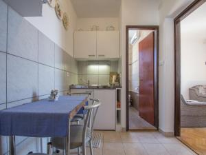 a kitchen with a table and chairs in a room at Apartments Stella in Selce