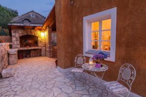 a patio with a table and chairs and a fireplace at Villa URSULA in Grižane