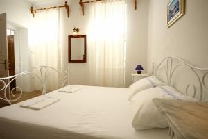 a bedroom with a white bed and a window at Villa URSULA in Grižane +44 photos