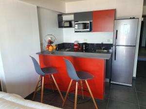 a kitchen with two stools and a counter with a refrigerator at LiveUshuaia Beagle View in Ushuaia