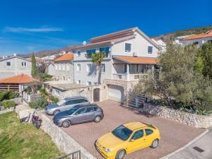 trzy samochody zaparkowane na parkingu przed domem w obiekcie Apartments Adriatic 2 w Crikvenicy