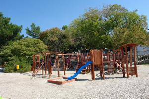a park with a wooden playground with a slide at Apartments Villa Katarina in Selce