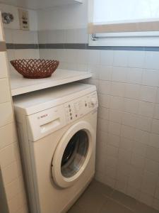 y baño pequeño con lavadora y secadora. en la casetta, en Abbadia Lariana