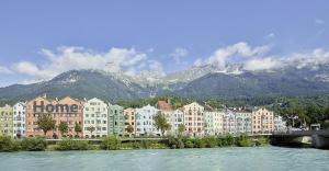 uma cidade com edifícios e um rio e montanhas em Modern apt in the most famous city postcard em Innsbruck