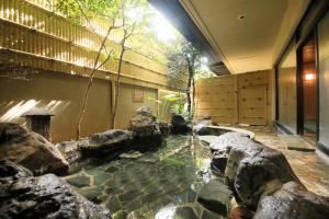 a koi pond in a building with rocks at Hanasuishou in Fuefuki +54 photos