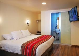 a bedroom with a bed with a television on the wall at Casa Durand in Cusco