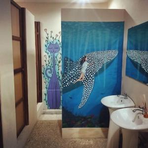 a bathroom with a dolphin shower curtain and a sink at StrayCat in San José