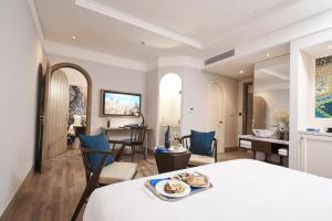 a bedroom with a bed and a living room at Sofiana My Khe Hotel & Spa- Rooftop Pool Bar in Danang