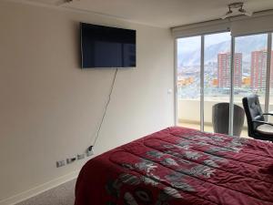a bedroom with a bed and a flat screen tv at Depto VIP Frente al Mar, Full Equipado y una Excelente Ubicacion in Iquique