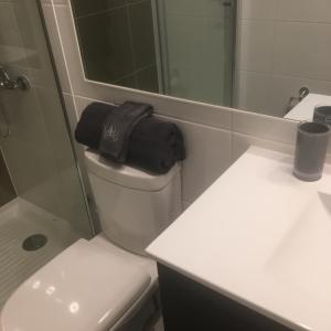 a bathroom with a toilet and a sink and a mirror at Depto VIP Frente al Mar, Full Equipado y una Excelente Ubicacion in Iquique +47 photos