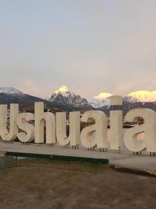 a large sign with snow covered mountains in the background at LiveUshuaia Beagle View Apartmento 2 dormitorios in Ushuaia