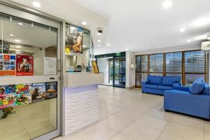 un vestíbulo de tienda con un mostrador y un sofá azul en Norfolk Luxury Beachfront Apartments, en Gold Coast