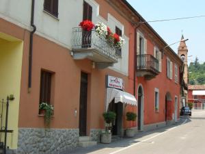 a building with flowers on the balconies on a street at Cà 'd Peraca in Monticello d'Alba