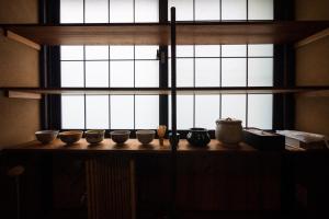 富山Kimachi-tei（きまち亭）的一组碗坐在窗前的桌子上 更多26张照片