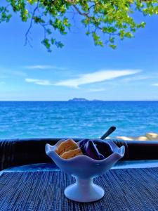 a bowl of food sitting on a table next to the ocean at Thalatta Resort in Zamboanguita