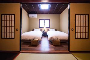 a room with two beds and a mirror at Kimachi-tei（きまち亭） in Toyama