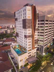 un gran edificio blanco con una piscina frente a él en CROWN PRINCE Hotel Surabaya Managed by Midtown Indonesia, en Surabaya