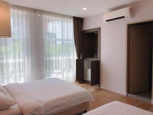 a bedroom with two beds and a large window at GPI HOTEL Bentong in Bentong