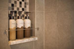 a bathroom with four shampoo bottles on a shelf at Tijili Seminyak in Seminyak