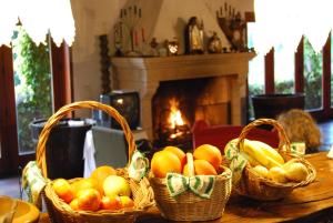 three baskets of fruit on a table with a fireplace at Casa Dos Canais, River Cottage in Marco de Canaveses