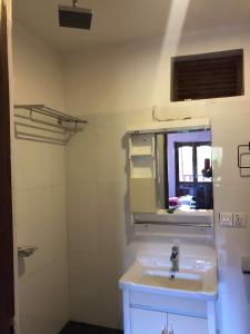 a bathroom with a sink and a mirror at The Hotel in Bandīpur