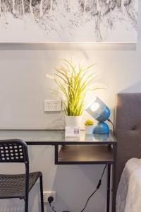 a table with a lamp and a plant on it at 1 Private King Single Bed With En-Suite Bathroom In Sydney CBD Near Train UTS DarlingHar&ICC&C hinatown - ROOM ONLY in Sydney