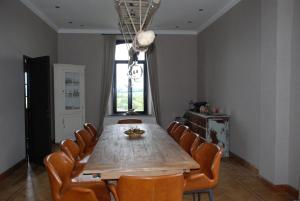 een eetkamer met een grote houten tafel en stoelen bij Monsieur Doute in Durbuy
