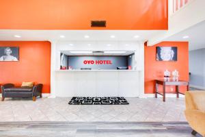 um lobby de um hotel com uma parede laranja em OYO Hotel Texarkana Trinity AR Hwy I-30 em Texarkana