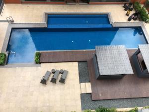 an overhead view of a swimming pool with tables and chairs at A Home with a view, 1 Bdrm with balcony and Netflix Access in Manila