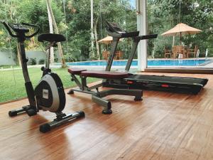 a gym with two exercise bikes next to a pool at Serenity Villa Digana in Kandy