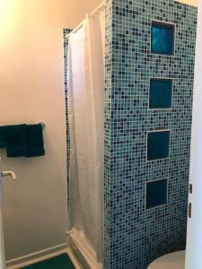 La salle de bains est pourvue d'une douche, de toilettes et d'un mur en carrelage. dans l'établissement Studio indépendant près cap canaille avec terrasse, à La Ciotat