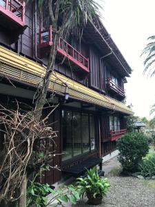 un bâtiment avec des fenêtres rouges et des plantes devant lui dans l'établissement Chikurakan, à Minamiboso