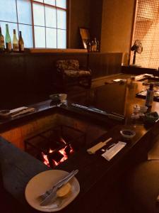 a table with a plate of food and a fire at Chikurakan in Minamiboso