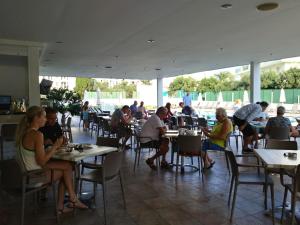 un grupo de personas sentadas en mesas en un restaurante en Livas Hotel Apartments, en Protaras