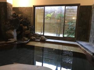 uma piscina com janela num quarto em Chikurakan em Minamiboso
