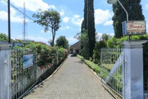een loopbrug door een tuin met een hek bij Villa Bunga in Malang