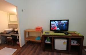 a living room with a television on a table at Palita Lodge - SHA Plus in Haad Rin