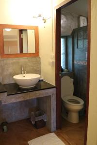 a bathroom with a sink and a toilet at Palita Lodge - SHA Plus in Haad Rin