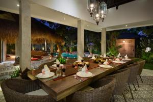 una sala da pranzo con un lungo tavolo e sedie di Villa Jumah a Seminyak