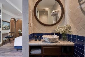 a bathroom with a sink and a mirror at Sofiana My Khe Hotel & Spa- Rooftop Pool Bar in Danang