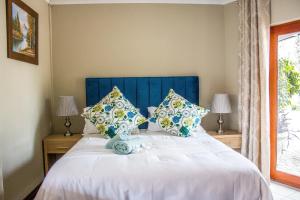 uma cama com cabeceira azul e almofadas em Pro Active Guest House em Pretoria