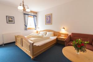 シュラニツェンにあるAparthotel Ederhofのベッドルーム1室(ベッド1台、ソファ、テーブル付)