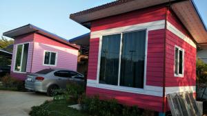 una casa rosa e rossa con una macchina parcheggiata di fronte di D&Dโฮม@เขาค้อ a Khao Kho