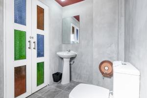 a white bathroom with a sink and a toilet at The Richy Place Guest House in Bangkok
