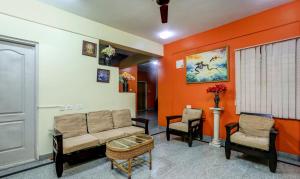 a living room with a couch and two chairs at Itsy By Treebo - Jasmine in Mysore