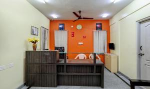 a living room with an orange wall at Itsy By Treebo - Jasmine in Mysore