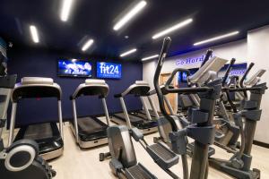 a gym with rows of cardio machines in a room at Ramada Hotel & Suites by Wyndham Yerevan in Yerevan