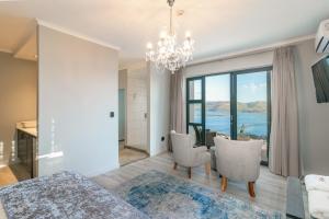 a living room with a chandelier and a table and chairs at Somervreug Guesthouse in Knysna